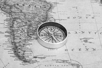 Classic round compass on background of old vintage map of world