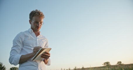 An Artistic Individual Engaged in Writing Creatively in the Peaceful Outdoors at Dusk