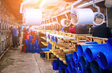 Production of glass fiber in a workshop with workers using machinery and preparing materials
