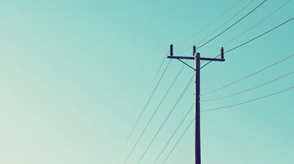 Minimalist Power Lines Extending from Utility Pole Against a Pale Blue Sky