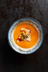 pumpkin soup with shrimps  in a bowl, top view