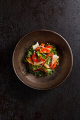 A fresh and vibrant vegetable salad, elegantly plated in a restaurant-style presentation.