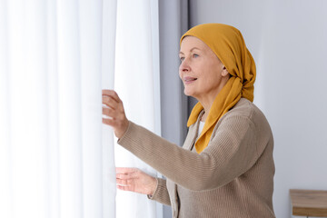 Senior woman with cancer near window at home