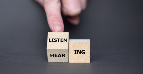 Hand turns cube and changes the word hearing to listening. 