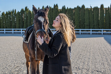 Fototapeta premium Woman in old money style with a horse. Quiet lifestyle. Lady have a time for riding. Horses concept
