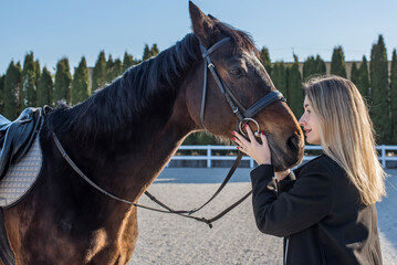 Fototapeta premium Woman in old money style with a horse. Quiet lifestyle. Lady have a time for riding. Horses concept