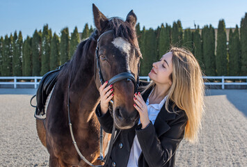 Fototapeta premium Woman in old money style with a horse. Quiet lifestyle. Lady have a time for riding. Horses concept