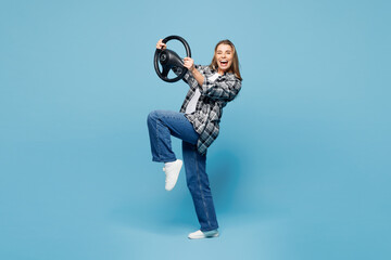 Full body side view young woman she wearing checkered grey shirt casual clothes hold steering wheel...