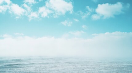 Obraz premium An expansive horizon where sky meets sea, enveloped in mist, evokes a sense of tranquility and boundless freedom under a vast blue sky.