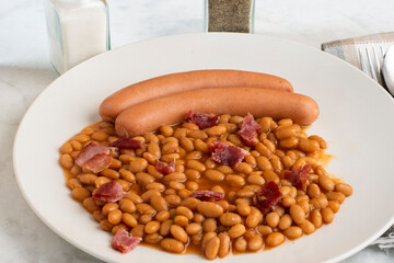 two hot dogs  served with bked beans  and bcaon bits