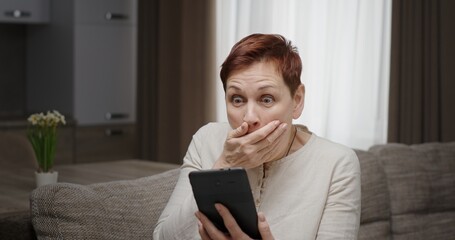 A stunned woman is left in disbelief and awe at the astonishing news on her tablet