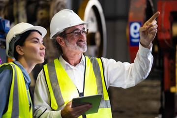 Two professional engineer worker working control sheet metal roof tile roll forming machine at metal sheet profiling factory. Industrial production. Teamwork
