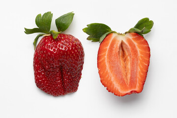 juicy red strawberry sliced in half with green leaves on white background, vibrant and fresh fruit
