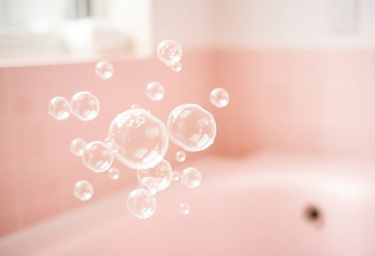 Grandes burbujas de jab&oacute;n en un ba&ntilde;o de color rosa claro 
