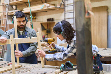 Young apprentice and mentor working together in a lumberyard