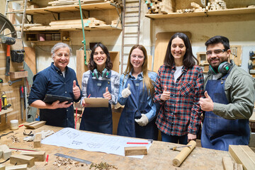 Team of young and experienced workers in a lumberyard workshop