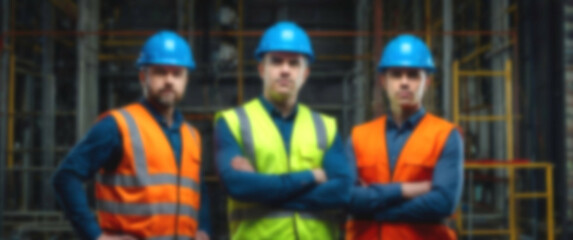 Blurred background capturing a skilled group of electricians in blue safety helmets, arms folded, demonstrating expertise and strict safety compliance