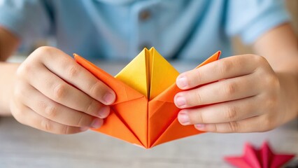 kids art craft and collage concept. Child folding colorful origami paper art in hands.