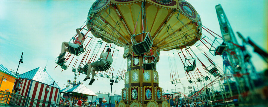 Panoramic view of tourists riding on an amusement park ride, Lynn's Trapeze, Luna Park, Coney Island, Brooklyn, New York City, New York State, USA.