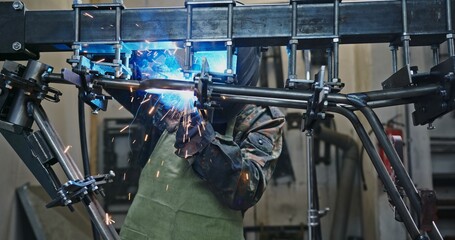 A Professional Welder skillfully executing the intricate process of creating metal frameworks