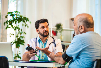 Obraz premium Concerned doctor checks BP of elderly patient, results seem out of range in a cozy clinic setting