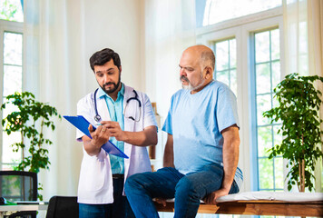 Fototapeta premium Indian Senior retired male patient undergoing physiotherapy assessment for shoulder, neck pain