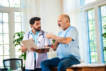 Indian Senior retired male patient undergoing physiotherapy assessment for shoulder, neck pain