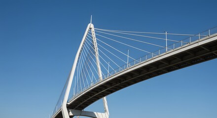 Naklejka premium Modern twisting bridge with steel and glass design against blue sky
