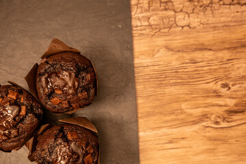 Top View of Chocolate Muffins on Rustic Slate and Wooden Surface