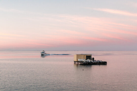 Horizontal shot of commercial cray fishing boats at sunrise with shack.