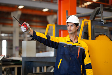 communicate by walkie talkie transmitter, radio. Hispanic man worker in safety hardhat helmet at...
