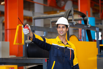 communicate by walkie talkie transmitter, radio. Hispanic man worker in safety hardhat helmet at...
