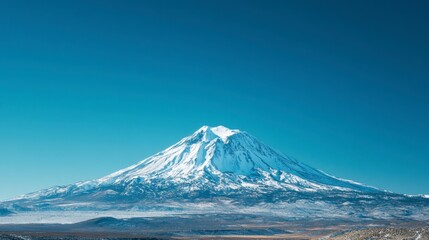 Majestic Snow-Capped Mountain Under Clear Blue Sky in Winter