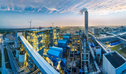 Aerial view of industrial plant and power station with wind turbine