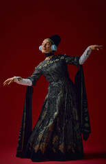 Elderly woman in intricate renaissance dress moving expressively with modern headphones, embodying...