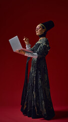 Elderly woman in ornate renaissance gown confidently working on laptop, embodying timeless wisdom...