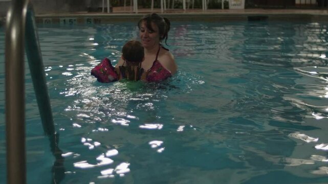 Mother and Daughter Swimming in Pool Spinning