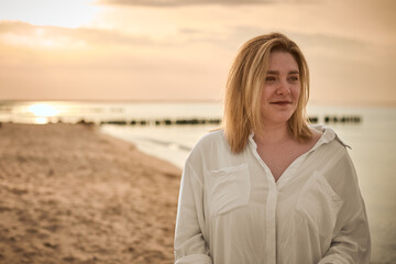 Serene woman enjoying sunset by beach
