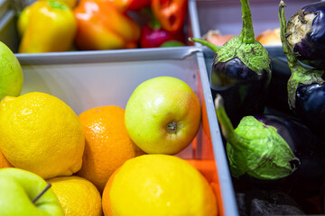 Various fruits and vegetables in boxes top view. Ripe apples, lemon, orange, grapefruit, eggplant, pepper on the market. Selective focus