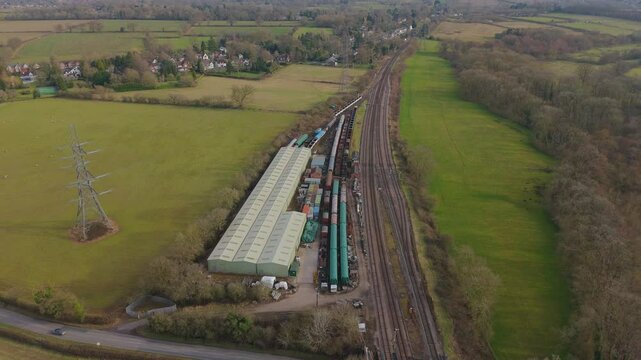 Aerial view drone of trainyard train tracks railway station in the English countryside on a sunny day UK Europe