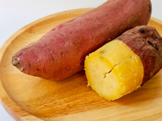 Close up side view. Baked Japanese sweet potato Beni Haruka on wooden board on white background