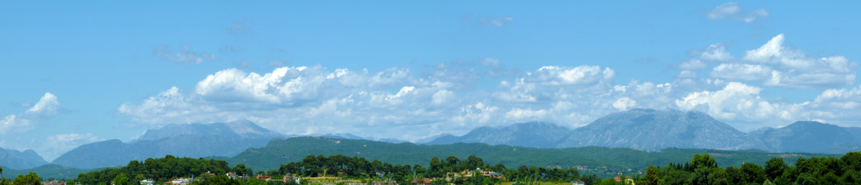T&uuml;rkiye's mountains. Panoramic view of southern T&uuml;rkiye's coastal mountscape at noon in early summer, showcasing their beauty under cloudy skies.