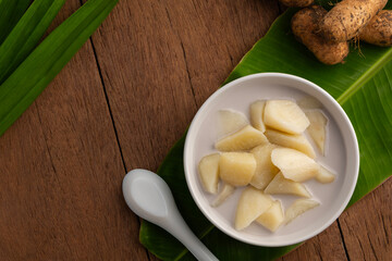 Coconut Milk Stewed yam (D. esculenta(Lour.) Burkill),Thai dessert boiled sliced Dioscorea esculenta yam in coconut milk with sugar in white bowl.Top view.