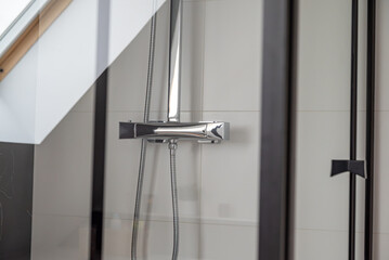 Zoom sur un projet de salle de bains finalisé. Gros plan sur la colonne de douche. Vue de la...