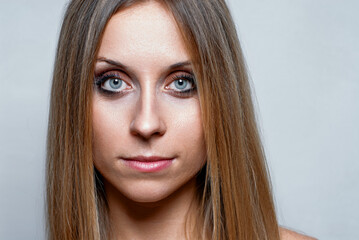 Fototapeta premium Close-Up Portrait of a Woman with Long Hair and Intense Blue Eyes