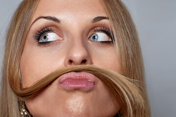 Playful Woman with Hair Mimicking a Mustache While Gazing Upwards..