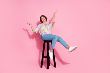 Full size photo of pretty young lady sit stool empty space wear shirt isolated on pink color...