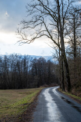 Fototapeta premium Dramatic sky over empty wet road at sunset