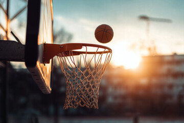 Basketball in mid-air approaching a basketball hoop.