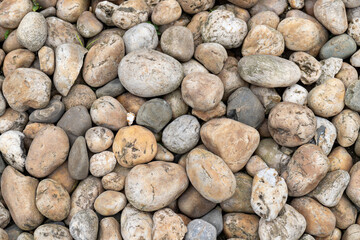 A pile of pebbles stacked against the background grain